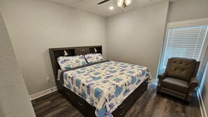 A bedroom with a bed, a chair, a ceiling fan, and a window with blinds. - Mtn Paradise Lake view Indoor/Outdoor pools/2 splash pads, Silver Dollar City (Branson)