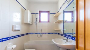 A bathroom with a toilet, bathtub, and sink. - Friendly Family Apartment at Ischia (Ischia)