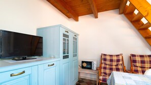 Cozy living space with a flat-screen TV, kitchenette, and seating area.