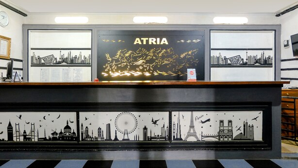 Un comptoir d’accueil orné d’une fresque représentant un paysage urbain et de photos encadrées de monuments célèbres.