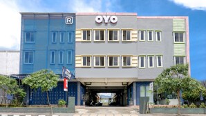 Un bâtiment portant l’enseigne « OYO » et dont la façade est bleue.