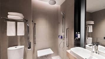 A modern bathroom with a shower, toilet, and sink.