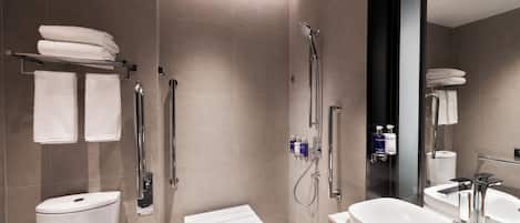 Un baño moderno con ducha, inodoro y lavabo.