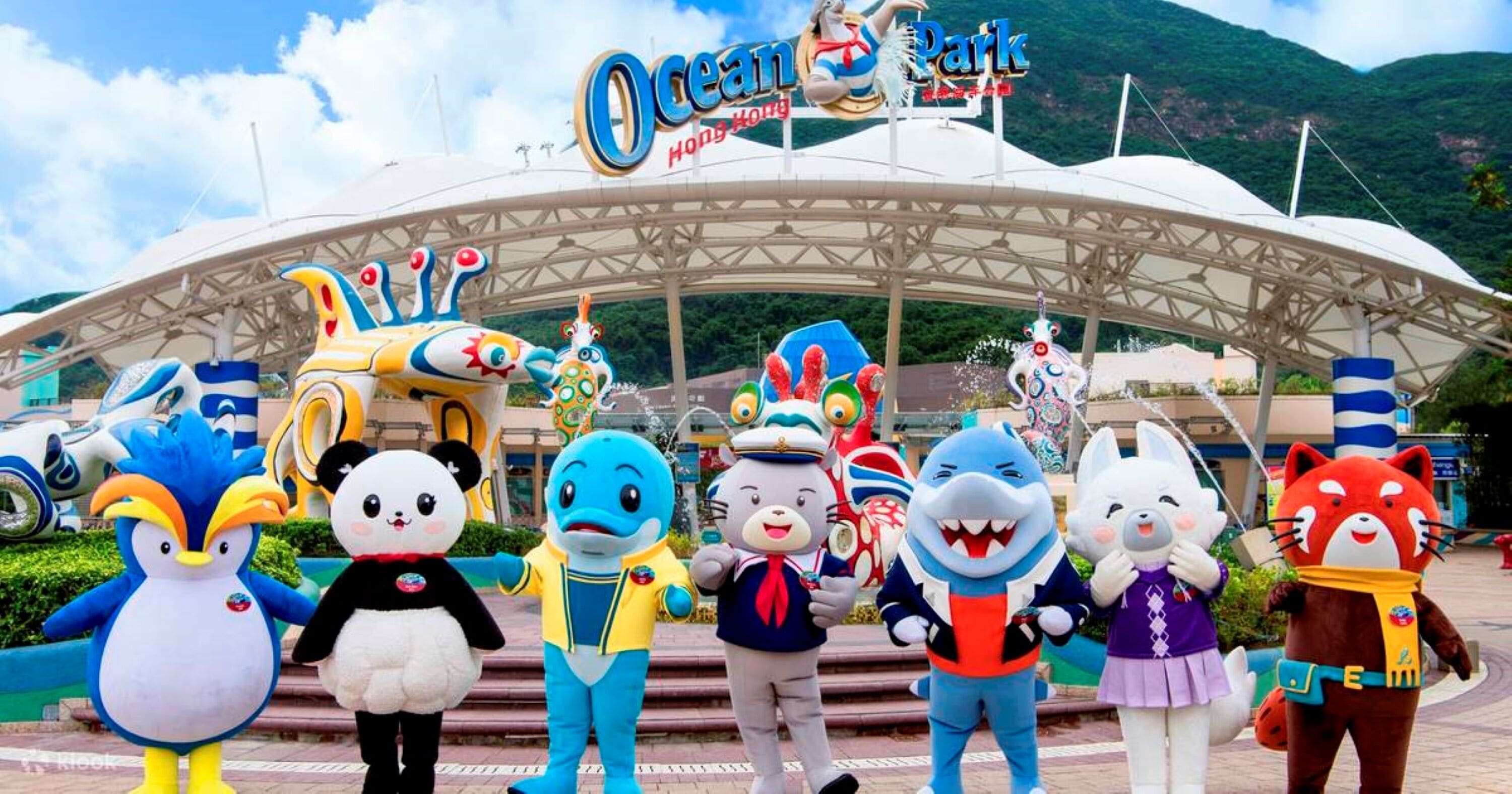A group of cartoon character mascots in front of a theme park entrance.