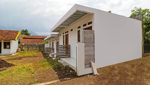 Un edificio moderno con techo plano, un porche cubierto y una pared de ladrillo.