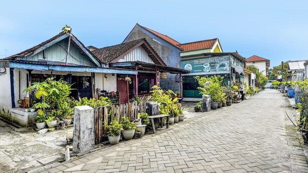 A narrow street lined with small shops and potted plants. - Hotel O Nurul Homestay Syariah (Gresik)