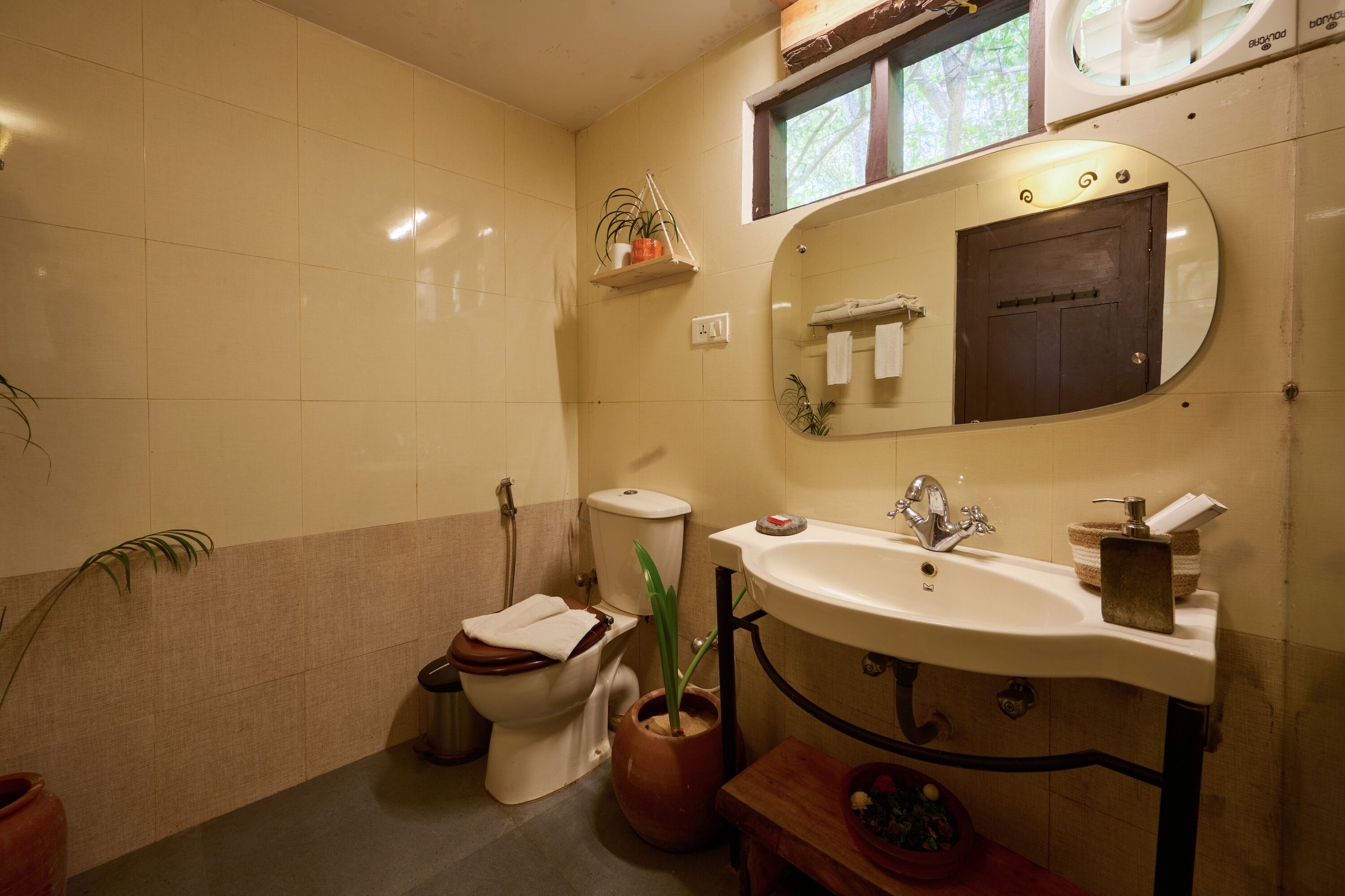 A bathroom with a toilet, sink, and mirror.