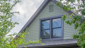 A house with a front porch, a red door, and a garden with yellow flowers. - The Garden House in Livingston (Livingston)