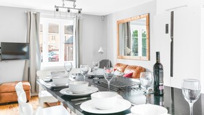 A dining area with a table set for four, a wine bottle, and a mirror above the table. - Quiet Peaceful Location (Bristol)