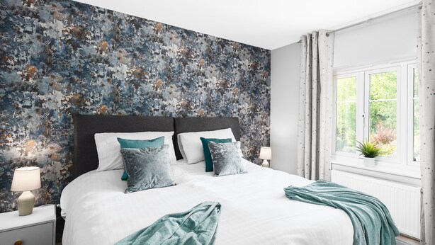 A bedroom with a large bed, white bedding, and a textured wall. - Quiet Peaceful Location (Bristol)