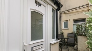 A white door with a glass panel and a small window, a mailbox, and a doorbell.