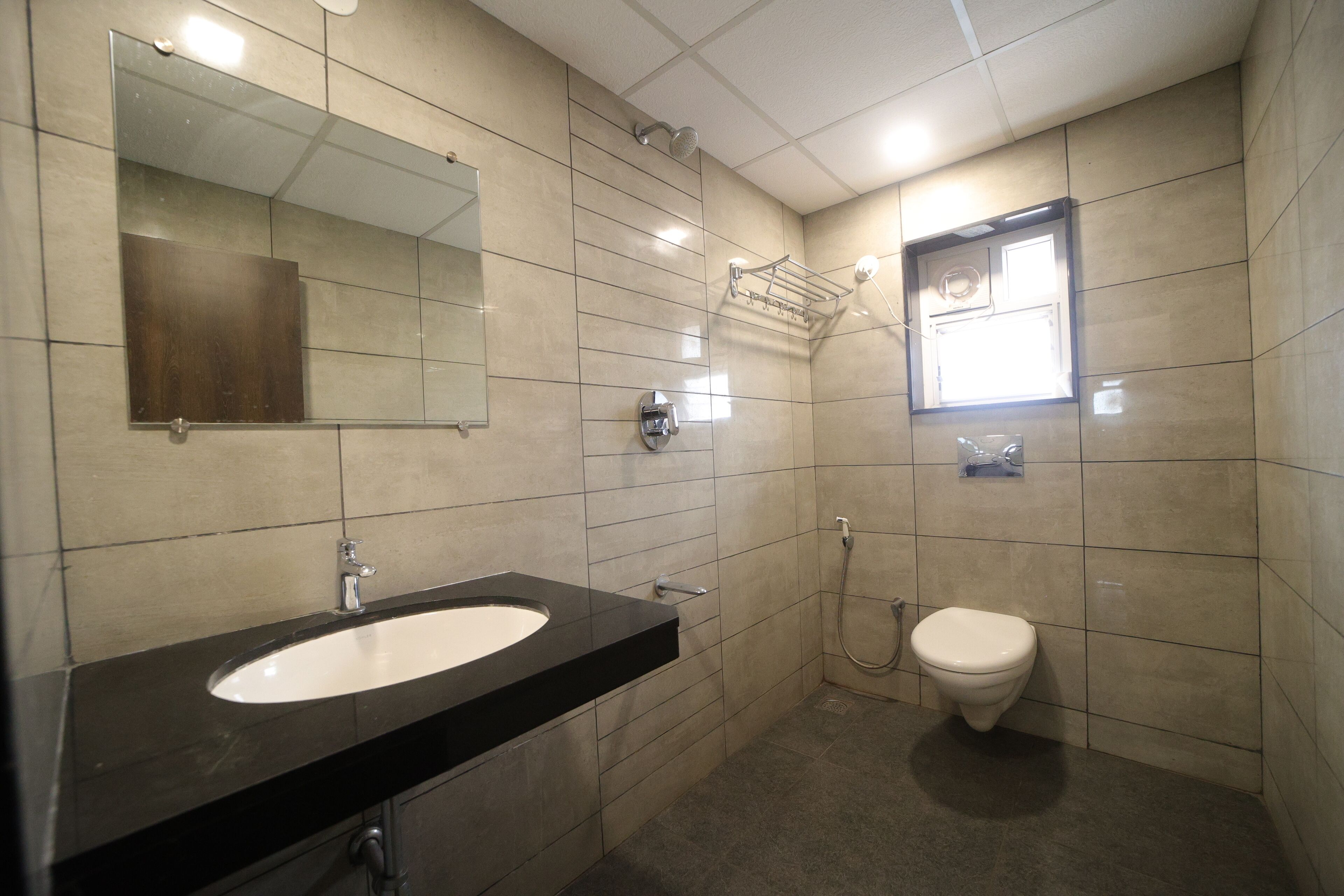 Een badkamer met een wastafel, spiegel, toilet en douche.