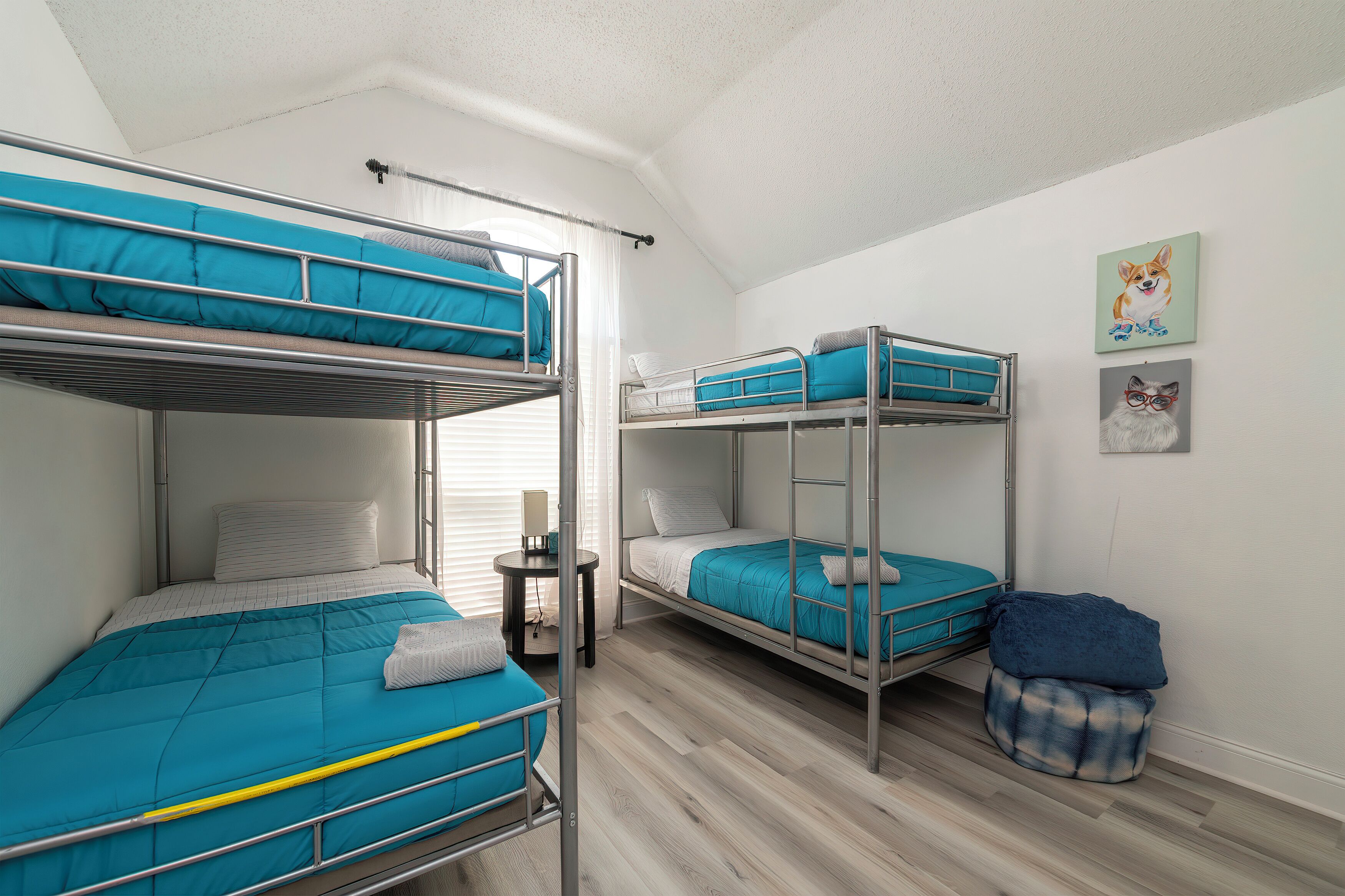 A bunk bed room with a desk and a small window.