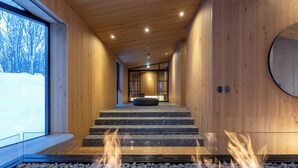 A modern interior with a wooden interior, a stone staircase, and a fire feature. - Hanaridge Residence 11 (Kutchan)
