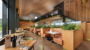 A restaurant with wooden booths, tables, and a bar area. - Bracken Hide Hotel (Portree)