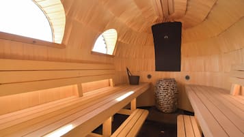 Un sauna avec des bancs en bois et un pilier central.
