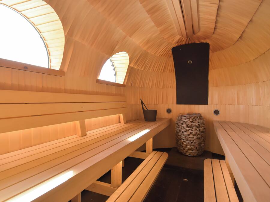 Un sauna avec des bancs en bois et un pilier central.