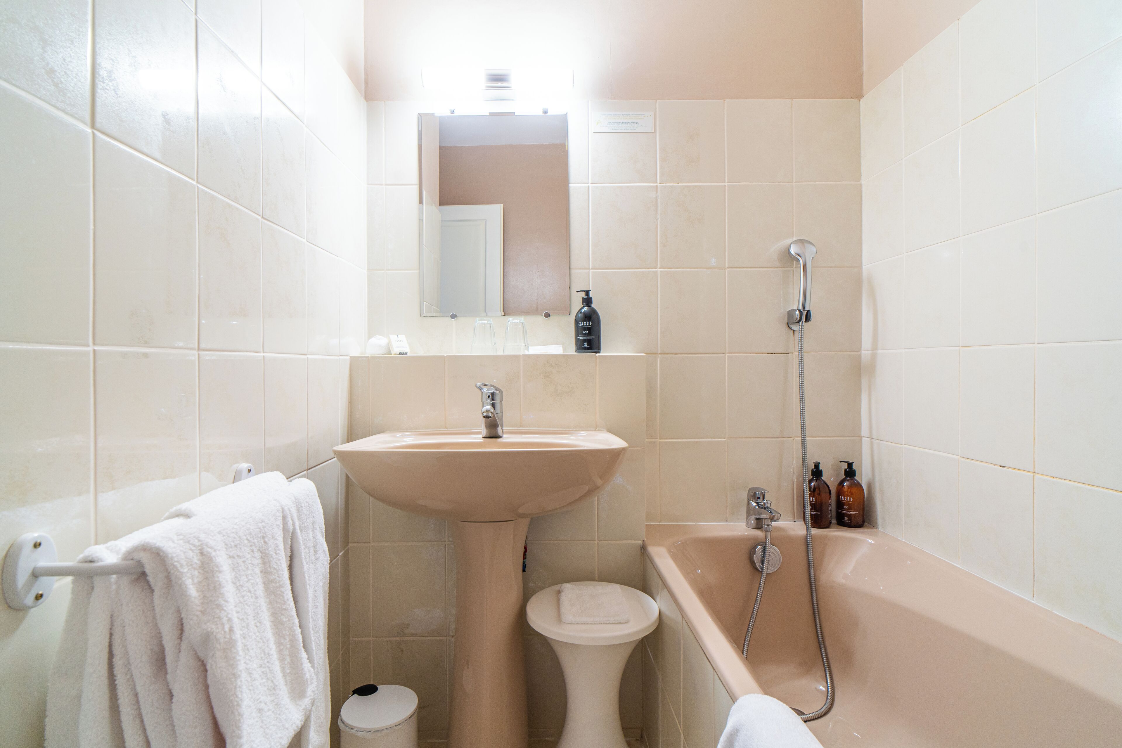 Ein Badezimmer mit Waschbecken, Spiegel, Toilette und Badewanne.