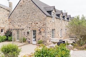 A stone building with a garden entrance, a door, and a window. - La Villa Bel Air (Flamanville)