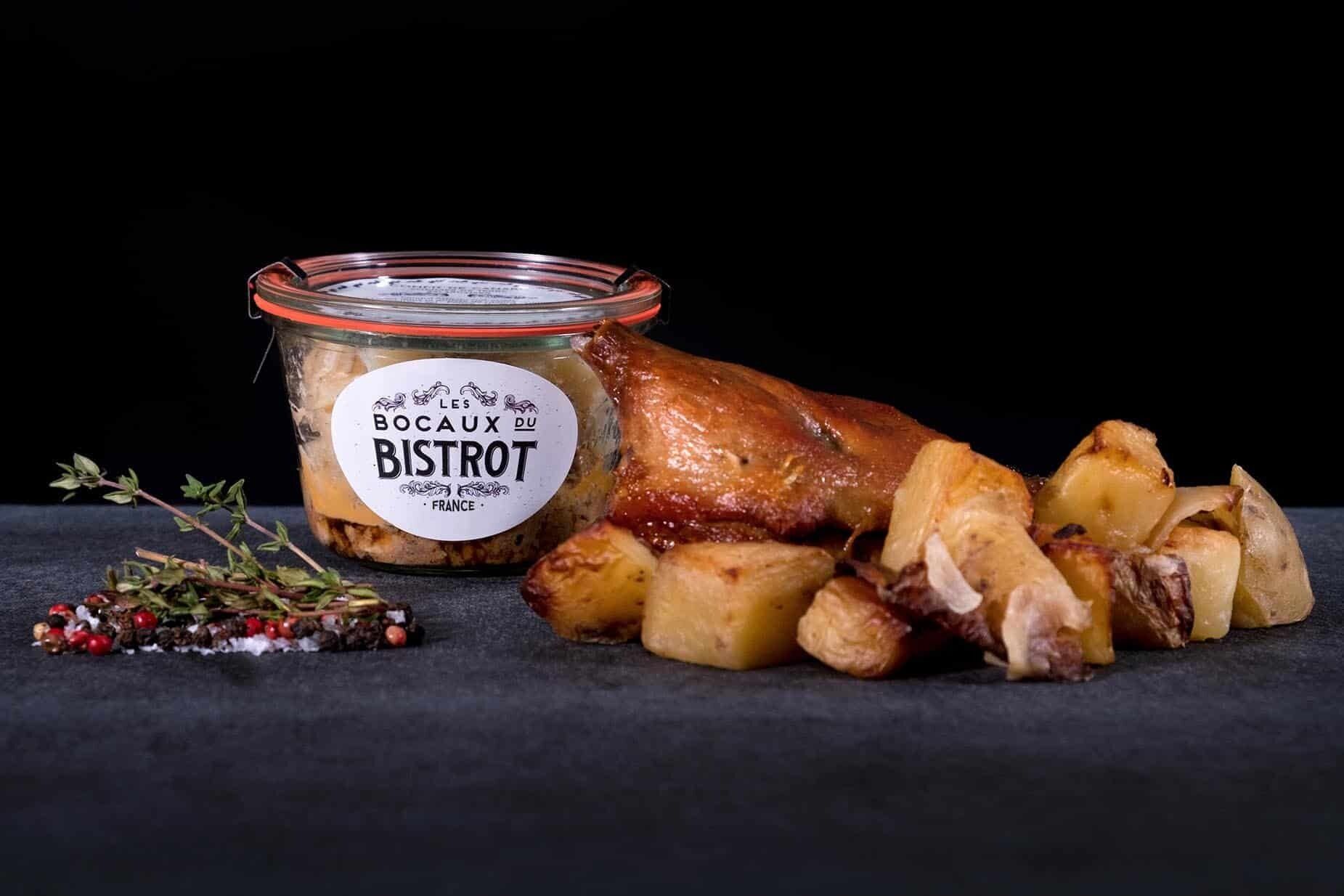 A roasted duck leg with potatoes and a jar of 'Les Bocas du Bistrot' sauce.