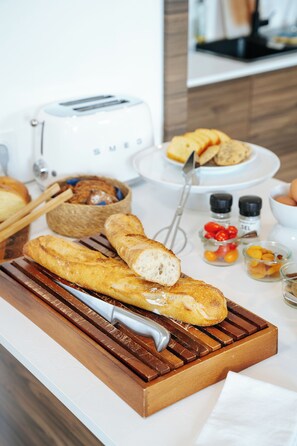 A breakfast setup with bread, a toaster, and condiments on a table. - La Villa Bel Air (Flamanville)