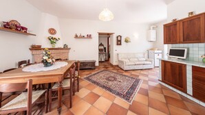 A spacious living area with a dining table, sofa, and kitchen area. - House Court - Irpinia (Montemarano)
