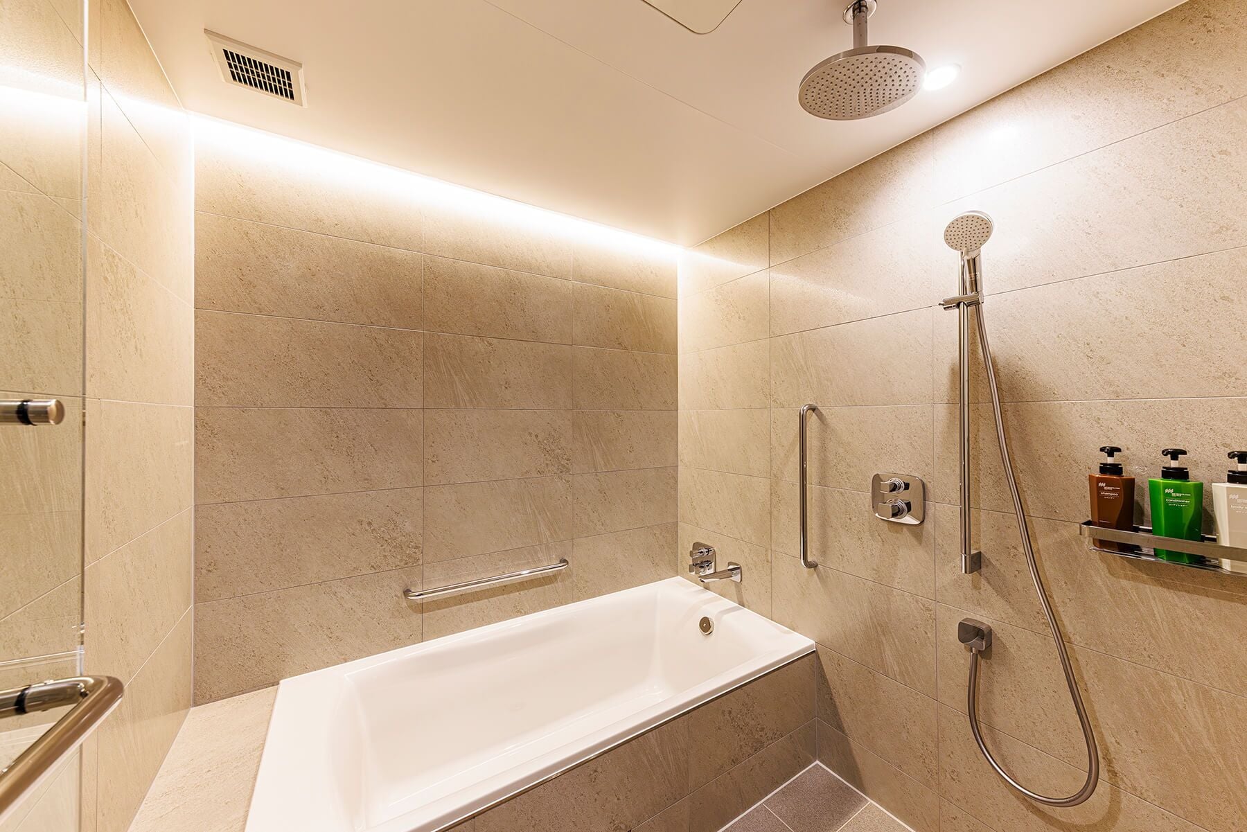 Un baño moderno con bañera, ducha con cabezal de mano y grifo empotrado.
