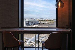 A view from a window overlooking an airport with airplanes on the tarmac.