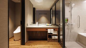 A modern bathroom with a wooden vanity, a glass shower enclosure, and a visible toilet.