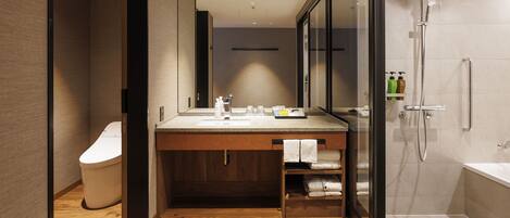 A modern bathroom with a wooden vanity, a glass shower enclosure, and a visible toilet.