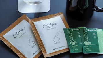 Two coffee bags, a glass of water, and a black mug on a table.