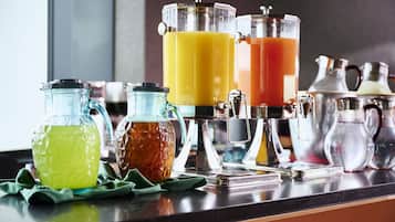 A kitchen counter with various glass containers holding different colored liquids, likely juices or beverages.