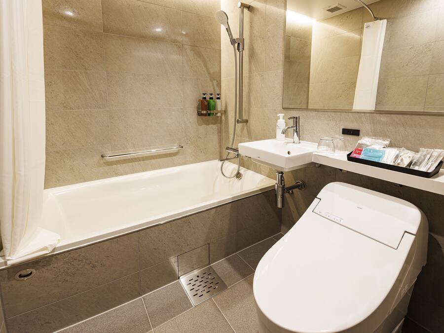 A modern bathroom with a bathtub, toilet, and sink.
