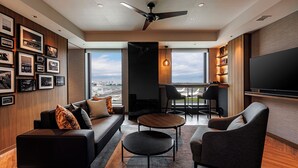 Un salon moderne avec un canapé, des fauteuils, une table basse et un téléviseur.