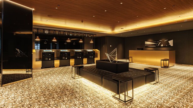 Un hall d’hôtel moderne avec un sol à motifs, un comptoir d’accueil et un espace salon.