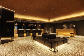 Un moderno vestíbulo de hotel con piso estampado, un mostrador de recepción y un área de descanso.
