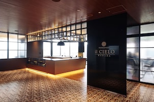 A modern interior with a central island counter, large windows, and patterned flooring.