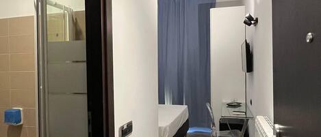 A modern bathroom with a glass shower enclosure, a toilet, and a sink.