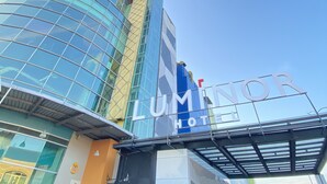 Un hotel con un letrero llamativo, fachada de vidrio y diseño arquitectónico moderno.