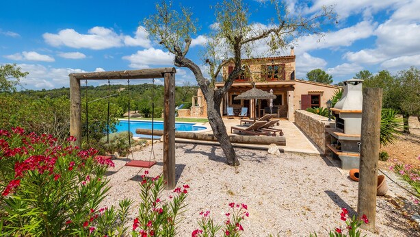 Una villa con piscina, mobiliario exterior y zona de barbacoa.