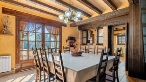 Un comedor con una mesa grande, sillas y una araña.