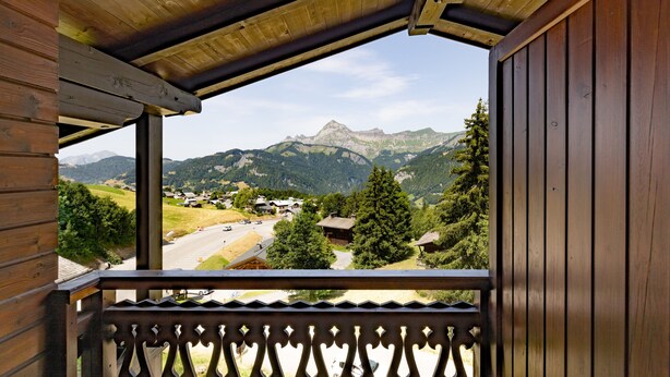 A wooden balcony with a view of a mountain range and a road. - Ski in/ski Out Holiday Apartment (Crest-Voland)