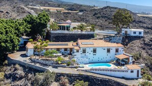 A coastal property with a swimming pool, multiple buildings, and a mountainous backdrop. - 'Biofinca Las Dulces Casa Almita' with Sea View, Private Terrace and Wi-Fi (Guia de Isora)