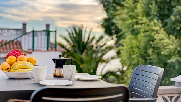 A table with a bowl of fruit, a coffee maker, and a chair. - 'Biofinca Las Dulces Casa Almita' with Sea View, Private Terrace and Wi-Fi (Guia de Isora)