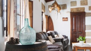Ein rustikales Interieur mit einem Holzfass, einer Glasflasche und Kiefernzapfen.