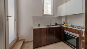 A modern kitchen with a built-in oven, a gas stove, a window, and a sink.