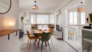 Une cuisine moderne avec un coin repas, un téléviseur et une fenêtre avec des rideaux.