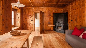 A wooden interior with a fireplace, a sofa, and a dining table. - Apartment 'Josephus - Domicilium I' with Mountain View, Shared Terrace and Wi-Fi (Madonna di Senales)
