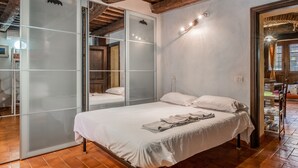 Un dormitorio con cama, puerta corrediza de vidrio y piso de madera.