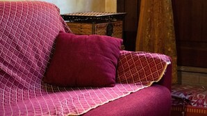 Un sofá con funda estampada y una sola almohada.